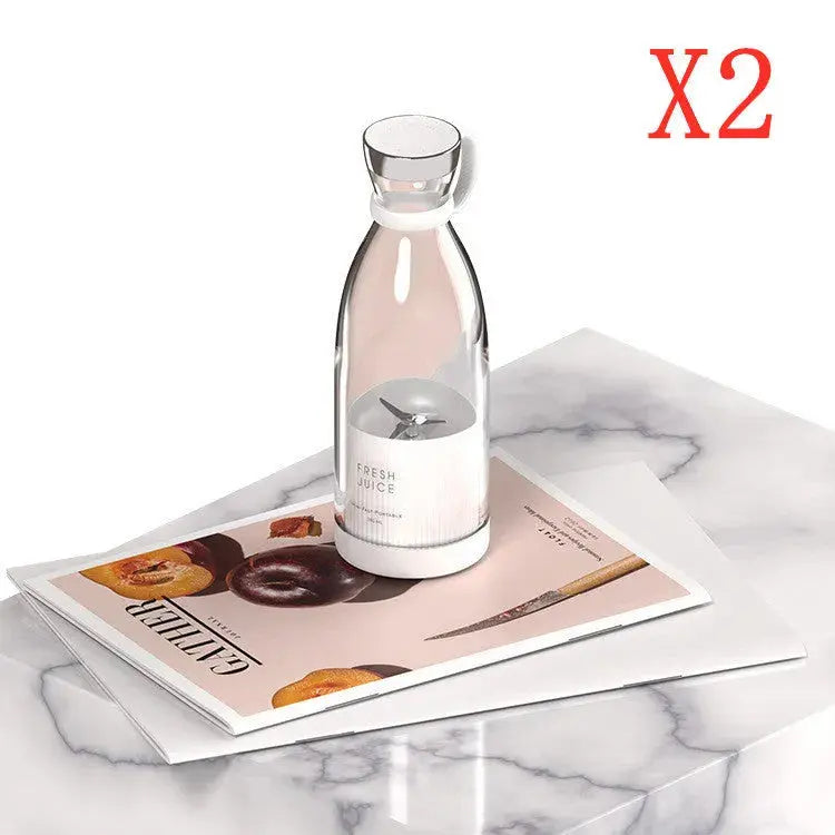 Clear glass bottle with a label on a magazine on a marble surface, with 'X2' in red text above.