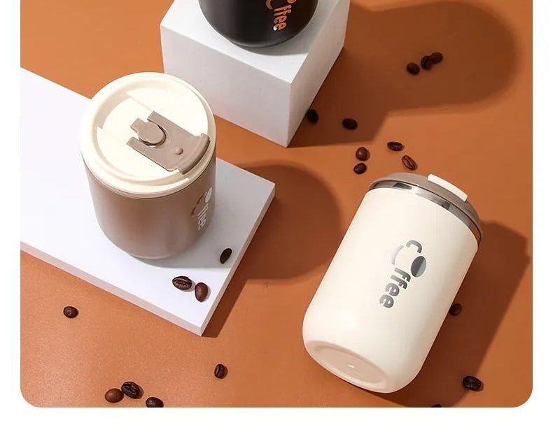 White coffee cup with lid, coffee beans on a brown surface, and three coffee-themed coasters.