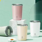 Set of four insulated tumblers in pink, beige, and white on a light green background.