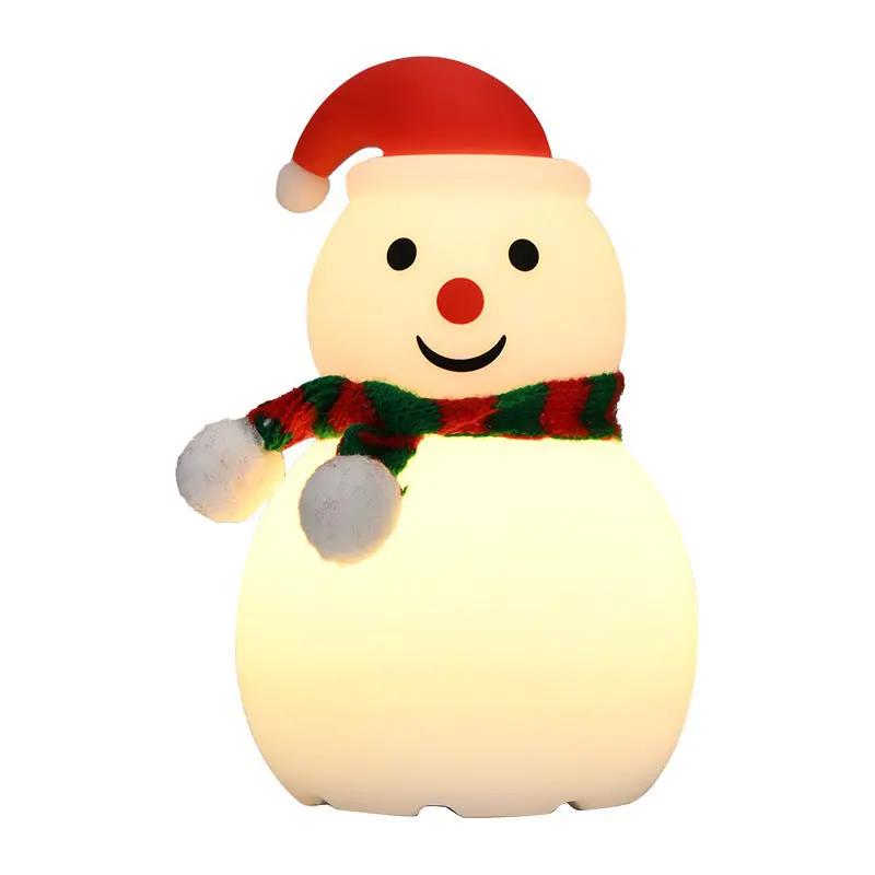 Snowman-shaped night light with a red hat and scarf on a white background