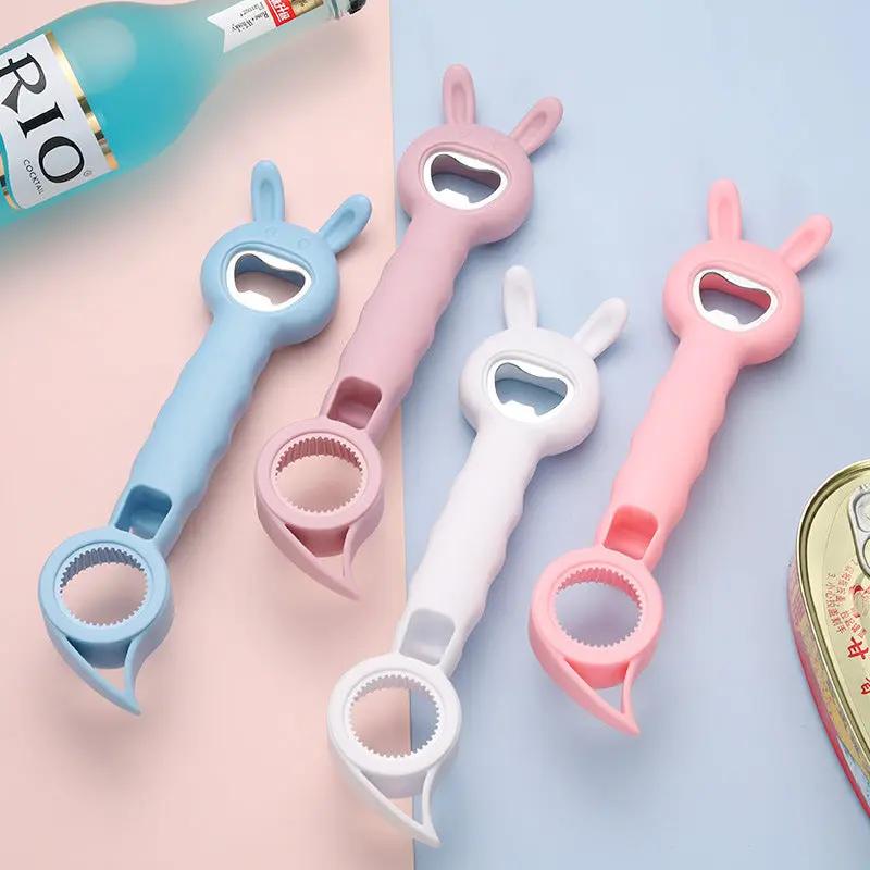 Four bunny-shaped bottle openers in blue, pink, white, and pink on a light blue background.