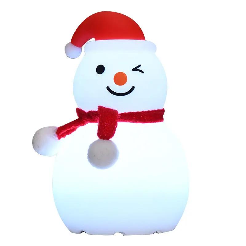 Snowman-shaped night light with a red hat and scarf on a white background