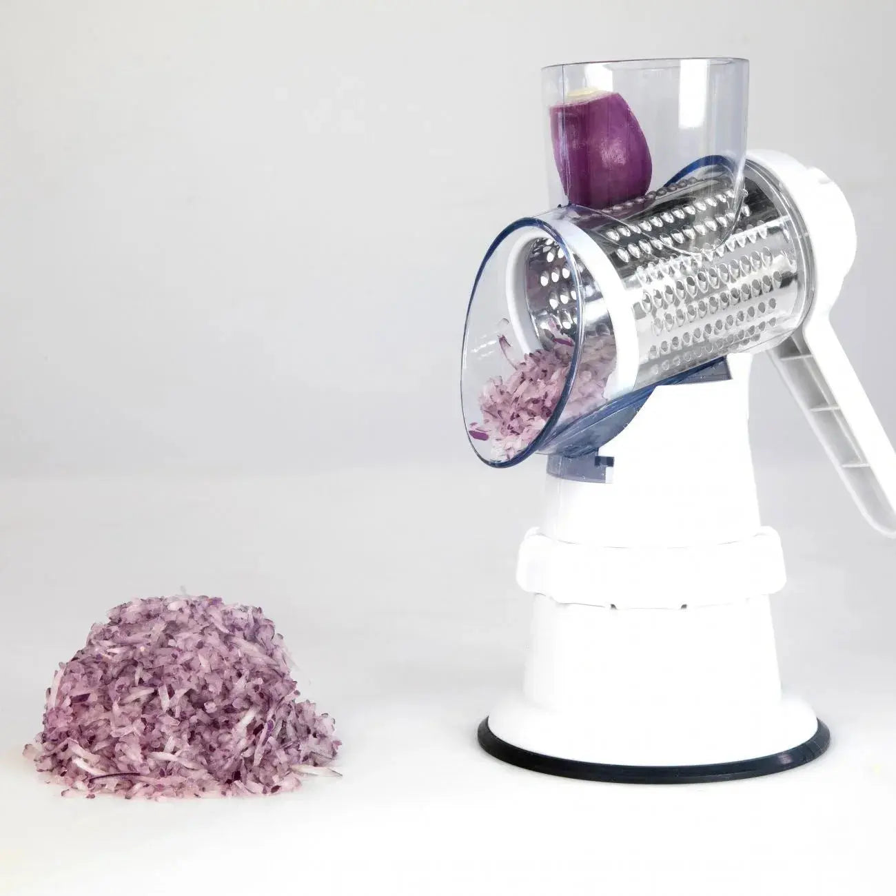 Manual onion chopper with shredded purple onion on a white background