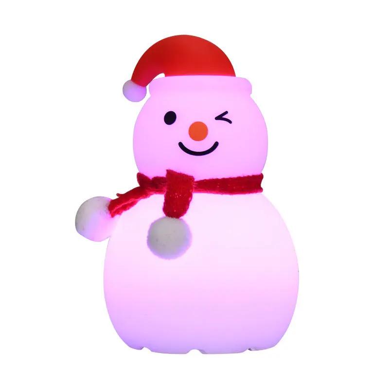 Pink snowman figurine with a red hat and scarf on a white background