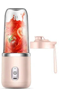 Personal blender with a pink base and clear container filled with a red smoothie on a white background