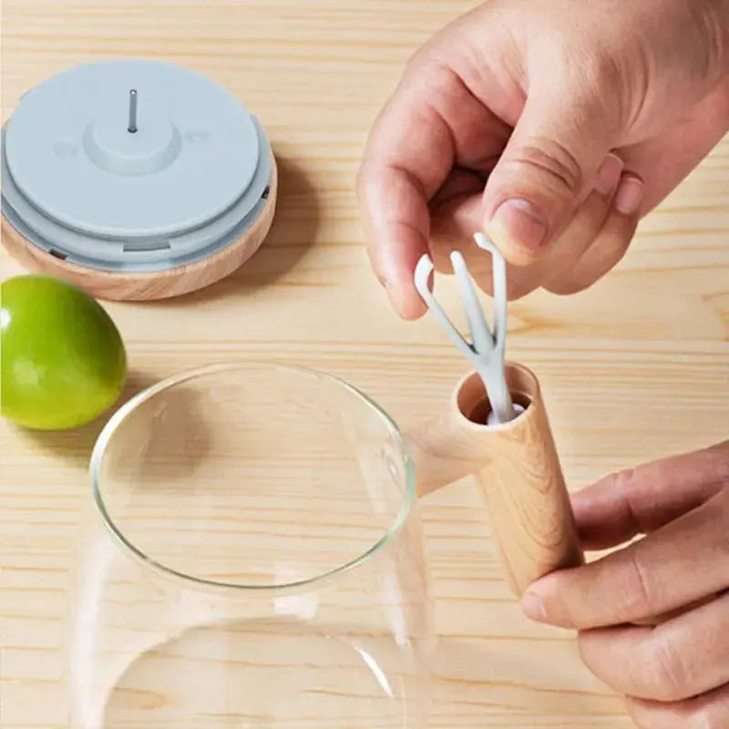 Person using a wooden utensil holder with cutlery on a wooden surface