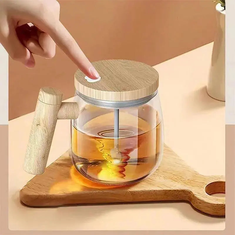 Glass teapot with wooden handle and lid on a wooden board, hand pointing at it.